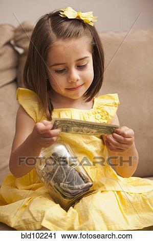 Caucasian girl putting money into jar View Large Photo Image Stock Image - Caucasian girl putting money into jar. Fotosearch