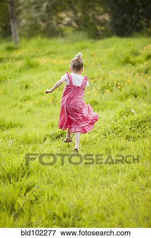 Stock Photo - Caucasian girl running in field. Fotosearch