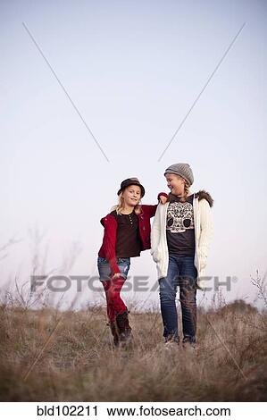 Stock Image - Caucasian girls standing in field. Fotosearch