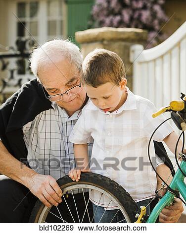 Caucasian grandfather and grandson repairing bicycle View Large Photo Image Stock Photo - Caucasian grandfather and grandson repairing bicycle. Fotosearch