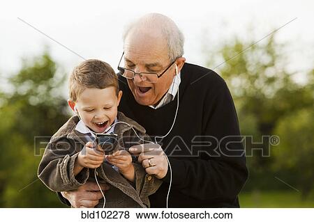 Caucasian grandfather and grandson listening to mp3 player View Large Photo Image Stock Photo - Caucasian grandfather and grandson listening to mp3 player. Fotosearch