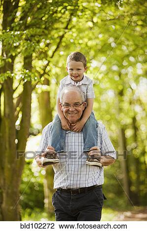 Caucasian grandfather carrying grandson on shoulders View Large Photo Image Stock Image - Caucasian grandfather carrying grandson on shoulders. Fotosearch