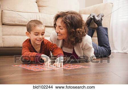 Caucasian grandmother and granddaughter playing cards on floor View Large Photo Image Picture - Caucasian grandmother and granddaughter playing cards on floor. Fotosearch