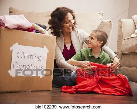 Stock Photo - Caucasian grandmother and granddaughter donating clothing. Fotosearch