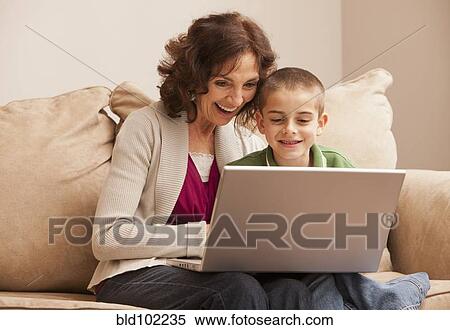 Stock Photography - Caucasian grandmother and granddaughter using laptop. Fotosearch