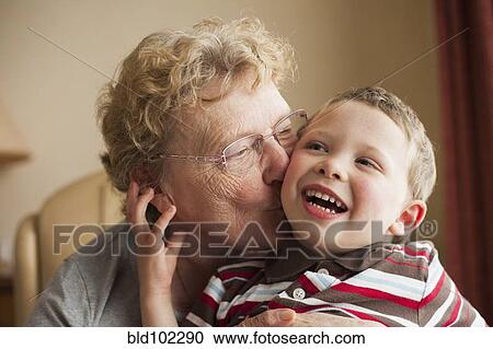 Stock Image - Caucasian grandmother kissing grandson. Fotosearch