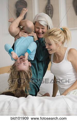 Caucasian grandmother, mother and daughter playing on bed View Large Photo Image Stock Photo - Caucasian grandmother, mother and daughter playing on bed. Fotosearch