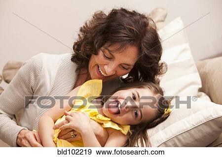 Caucasian grandmother tickling granddaughter View Large Photo Image Stock Photo - Caucasian grandmother tickling granddaughter. Fotosearch