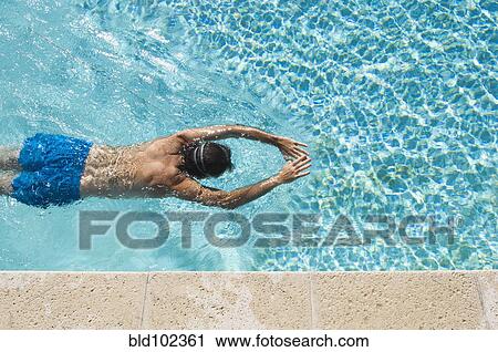 Stock Image - Caucasian man swimming in pool. Fotosearch