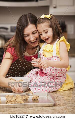 Stock Photo - Caucasian mother and daughter baking cookies. Fotosearch