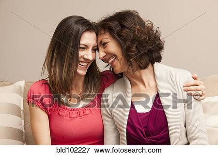 Caucasian mother and daughter sitting on sofa View Large Photo Image Stock Photo - Caucasian mother and daughter sitting on sofa. Fotosearch