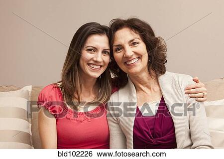 Caucasian mother and daughter sitting on sofa View Large Photo Image Stock Photograph - Caucasian mother and daughter sitting on sofa. Fotosearch