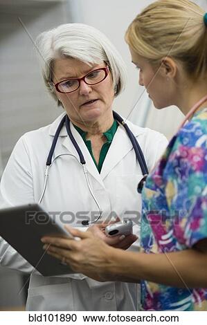 Stock Image - Caucasian nurse and doctor using digital tablet. Fotosearch