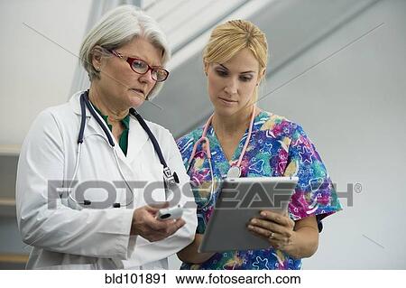 Stock Image - Caucasian nurse and doctor using digital tablet. Fotosearch