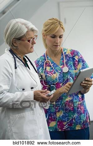 Stock Image - Caucasian nurse and doctor using digital tablet. Fotosearch