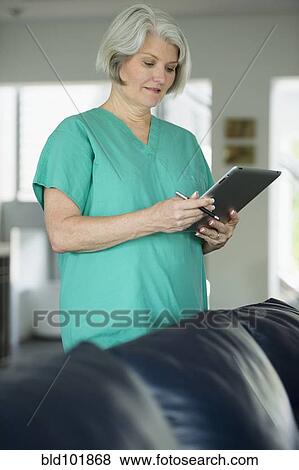 Stock Photo - Caucasian surgeon using digital tablet. Fotosearch