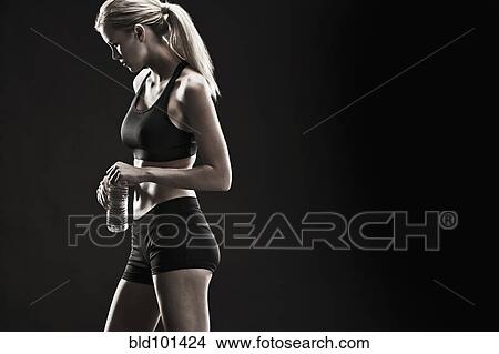 Picture - Caucasian woman drinking water after exercise. Fotosearch