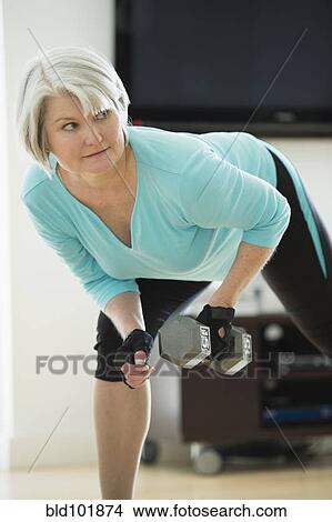 Picture - Caucasian woman exercising with hand weights. Fotosearch