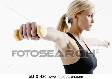 Stock Image - Caucasian woman exercising with hand weights. Fotosearch