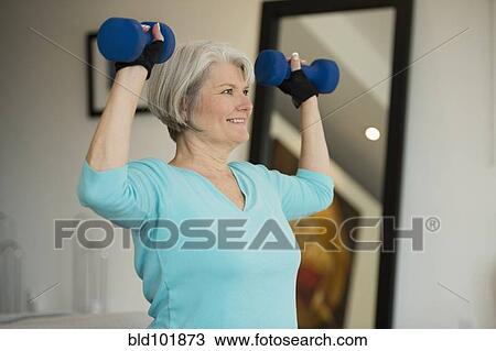 Stock Image - Caucasian woman exercising with hand weights. Fotosearch