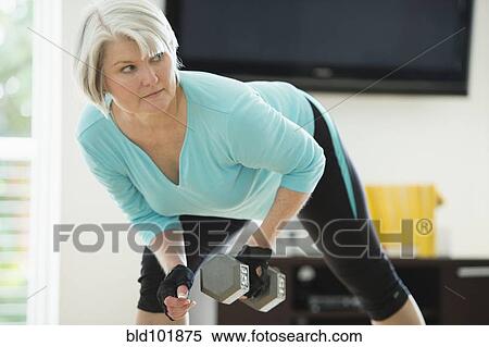Stock Photography - Caucasian woman exercising with hand weights. Fotosearch