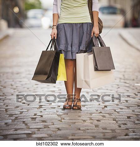 Stock Image - Caucasian woman holding shopping bags. Fotosearch