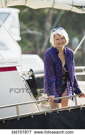 Stock Photo - Caucasian woman in bathing suit standing on boat. Fotosearch