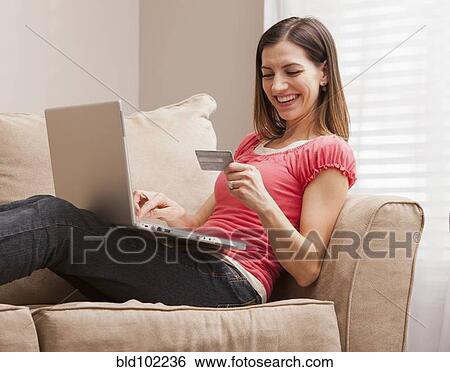 Stock Photograph - Caucasian woman shopping online with credit card. Fotosearch