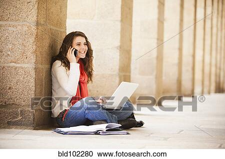 Caucasian woman sitting on ground with laptop and talking on cell phone View Large Photo Image Stock Image - Caucasian woman sitting on ground with laptop and talking on cell phone. Fotosearch