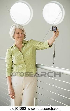Caucasian woman taking digital self-portrait View Large Photo Image Stock Image - Caucasian woman taking digital self-portrait. Fotosearch