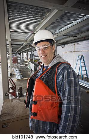 Stock Photo - Caucasian worker on construction site. Fotosearch