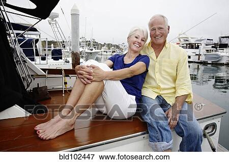 Couple relaxing on boat in marina View Large Photo Image Stock Photo - Couple relaxing on boat in marina. Fotosearch