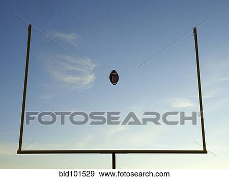 Stock Photo - Football being thrown through goal posts. Fotosearch
