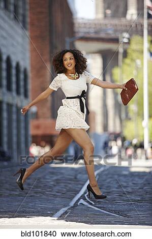 Glamorous mixed race woman running on urban street View Large Photo Image Stock Image - Glamorous mixed race woman running on urban street. Fotosearch