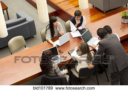 Stock Photo - Hispanic business people having meeting in conference room. Fotosearch