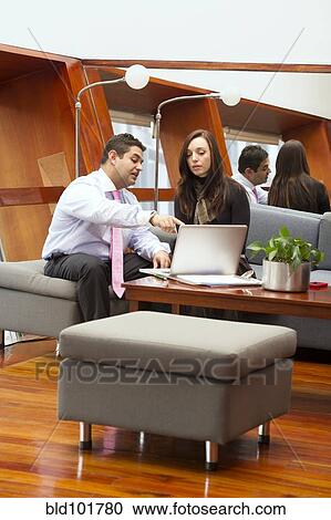Stock Image - Hispanic business people in meeting together. Fotosearch