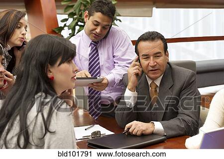 Stock Image - Hispanic business people in meeting. Fotosearch