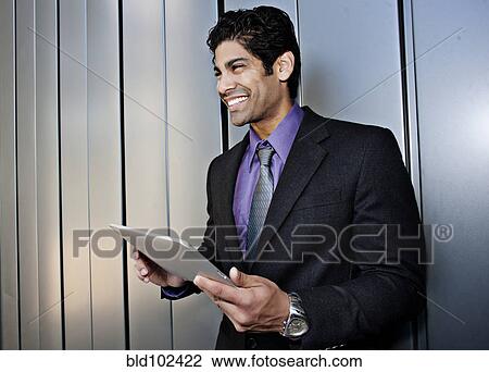 Hispanic businessman holding digital tablet View Large Photo Image Stock Image - Hispanic businessman holding digital tablet. Fotosearch