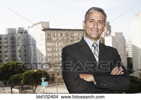 Picture - Hispanic businessman standing outdoors. Fotosearch