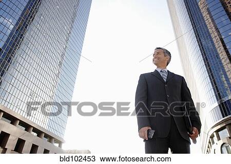 Hispanic businessman standing outdoors View Large Photo Image Stock Image - Hispanic businessman standing outdoors. Fotosearch