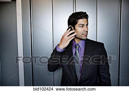 Hispanic businessman talking on cell phone View Large Photo Image Picture - Hispanic businessman talking on cell phone. Fotosearch