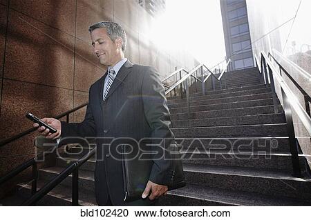 Hispanic businessman text messaging on steps View Large Photo Image Stock Image - Hispanic businessman text messaging on steps. Fotosearch