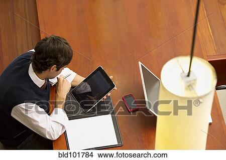Hispanic businessman using digital tablet View Large Photo Image Picture - Hispanic businessman using digital tablet. Fotosearch