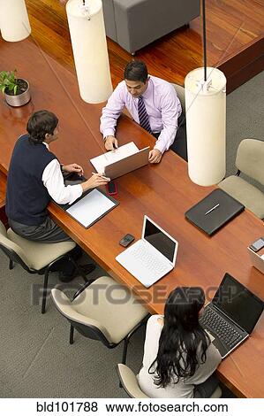 Stock Photo - Hispanic businessmen having meeting in conference room. Fotosearch