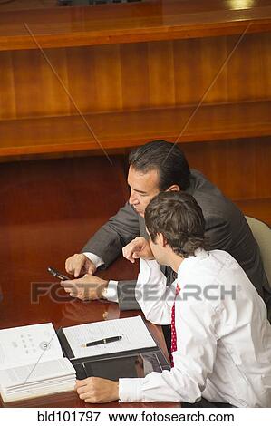 Stock Photo - Hispanic businessmen in meeting in conference room. Fotosearch