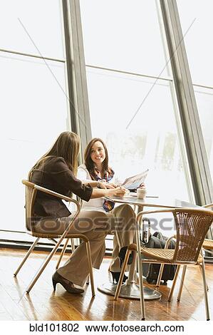 Stock Image - Hispanic businesswomen having lunch together. Fotosearch
