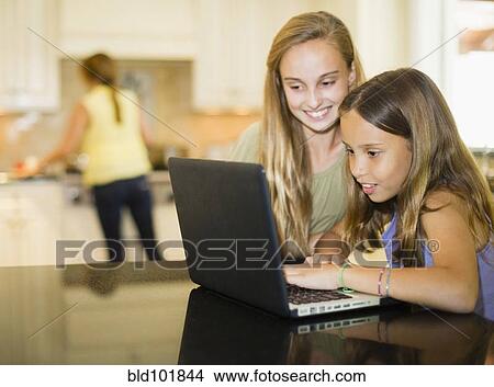 Picture - Hispanic girls using laptop together. Fotosearch