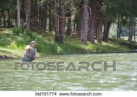 Picture - Hispanic man fishing in lake. Fotosearch