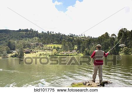Stock Photography - Hispanic man fishing in lake. Fotosearch