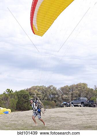 Stock Photo - Hispanic man paragliding. Fotosearch